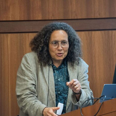 Neta Crawford speaking at a podium at UofL