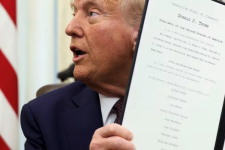 U.S. President Donald Trump holds up one of a flurry of executive orders signed within days of taking office. (Kevin Lamarque/Reuters)