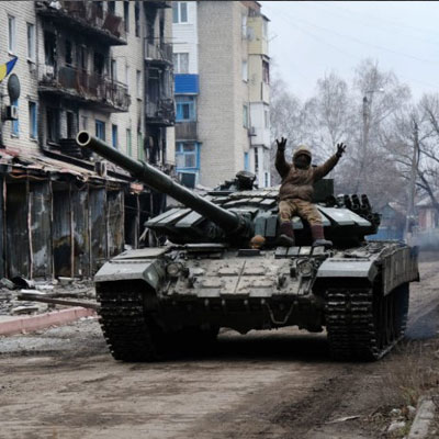 A Ukrainian tank drives down a street in the heavily damaged town of Siversk