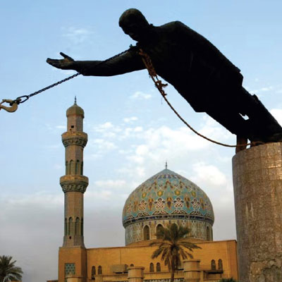 A statue of a man being pulled down from its pedestal by a crane