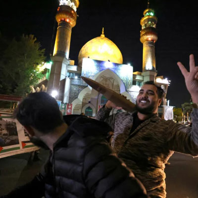 A demonstrator holds a replica missile shell as people gather in support of Iran's attack on Israel in Tehran's Palestine Square 