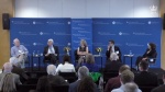 Stephen Van Evera sitting on a platform with 3 other panelists and a moderator in front of an audience