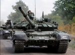 Soldiers driving two tanks down the road